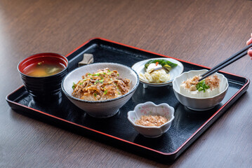 A delicious Japanese meal with beef, rice, miso soup, and pickles.