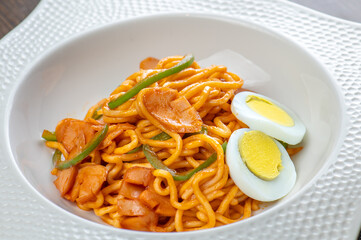 A plate of spaghetti with sausage and eggs.