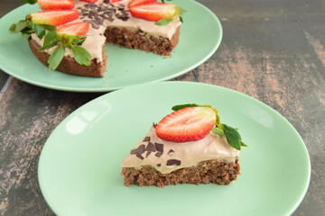 Strawberry oatmeal chocolate cake top with yogurt, shaved chocolate and fresh strawberry