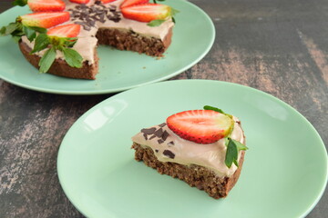 Strawberry oatmeal chocolate cake top with yogurt, shaved chocolate and fresh strawberry