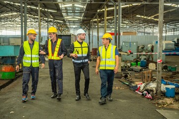 Group of engineer foreman walk line of troops straight in and talk together at end time of work in old Factory. unity teamwork colleague foreman and trainee walk straight in and talk collaboration.