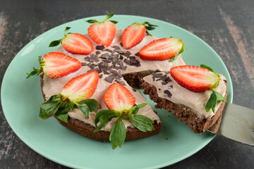 Strawberry oatmeal chocolate cake top with yogurt, shaved chocolate and fresh strawberry