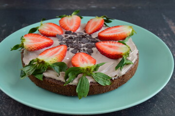 Strawberry oatmeal chocolate cake top with yogurt, shaved chocolate and fresh strawberry