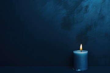 Navy Blue background with white thin wax candle with a small lit flame for funeral grief death dead sad emotion with copy space texture for display 