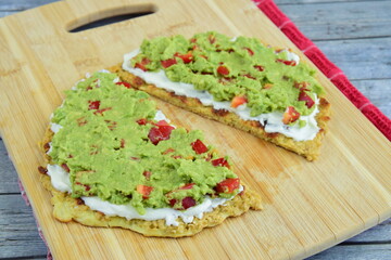oatmeal breakfast pancakes with mashed avocado, red bell pepper and cream cheese on wooden board