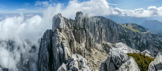 A breathtaking view of a rugged mountain peak, with jagged cliffs and sheer rock faces towering...