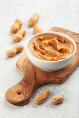 smooth peanut butter in bowl on gray background