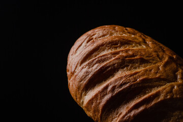 Loaf of bread on a black background. Fresh bakery