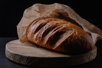 Loaf of bread on a black background. Fresh bakery