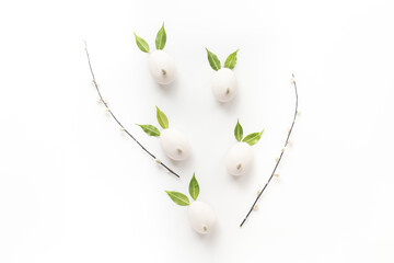 White Easter eggs in shape of bunnies with spring green leaves and willow sprig
