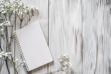 Home office workspace layout white blank empty form or sheet blocknote or checklist white gypsophila flower on light wooden background on background. Mockup place to write. Top view and copy space