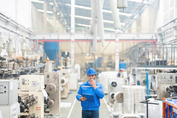 At the heart of the plastic and steel factory, the European engineer expertly navigates machinery...