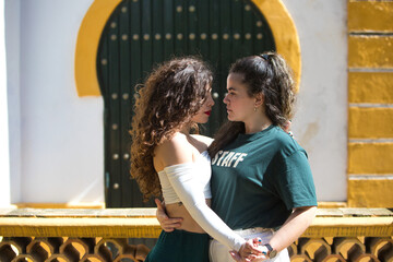 Portrait of a couple of young women dancing to different types of Latin music and dance. The two...