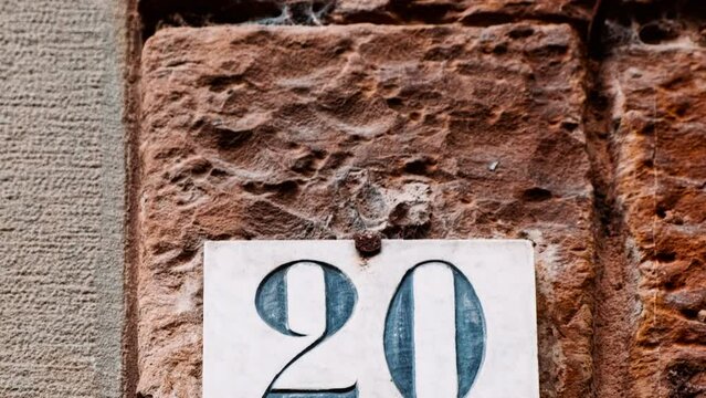 Number 20 (twenty) affixed to the exterior of a building, with an elegant, vintage and traditional appearance