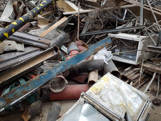 Pile of Mixed Scrap Metal and Construction Waste at a Dump Site. Industrial waste disposal and recycling concept. Design for environmental posters, waste management banners.
