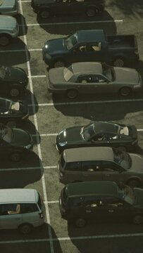 A bustling parking lot filled with a multitude of cars parked in neat rows.