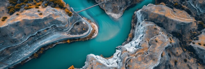 Naklejka premium Dramatic aerial perspective of a winding river carving its way through rugged canyons, showcasing nature's artistry