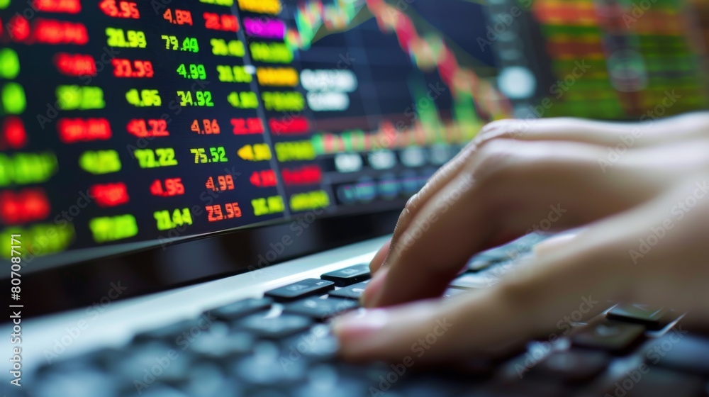 Aufkleber A hand typing on a keyboard with a stock market trading platform on the computer screen, emphasizing the importance of information technology in trading.