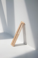 a wooden comb in front of a white wall