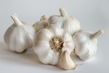 Group of whole garlic bulbs and individual cloves on a white background, highlighting healthy cooking ingredients