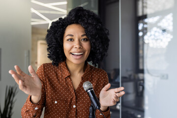 Confident young African American woman speaking passionately at a business seminar or conference,...
