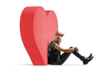 Punk rocker with a mohawk sitting on the ground and leaning on a red heart