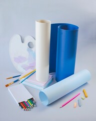 Back to school concept, on the student desk there are stationery, colored pencils, a palette with...