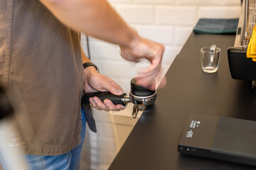 Barista hands expertly attaching a portafilter to an espresso machine