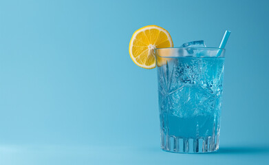 Alass of a vivid blue cocktail, such as a Blue Lagoon, placed against a matching blue backdrop. 