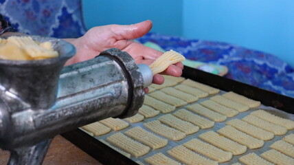Baking Fresh Butter Cookies: Cookie Dough Extruded from a Press onto a Baking Sheet in Rows