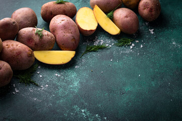 Raw uncooked potato on green table