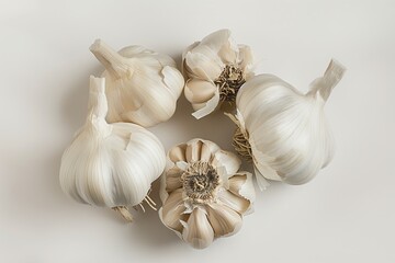 A group of whole garlic bulbs neatly arranged on a light background with natural shadows