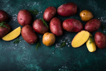 Raw uncooked potato on green table