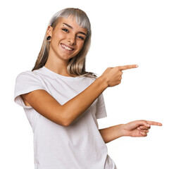 Young caucasian young woman in studio pointing with forefingers to a copy space, expressing...