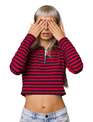 Young caucasian young woman in studio afraid covering eyes with hands.