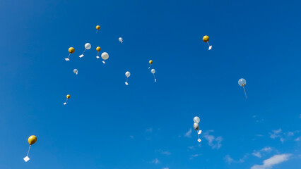 Luftballons mit Glückwunschkarten am blauen Himmel