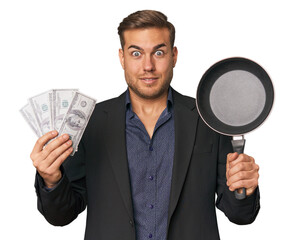 Man with dollars and pan, blending finance and cooking in studio