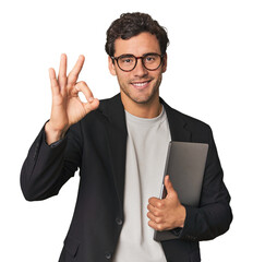 Young Hispanic businessman with laptop cheerful and confident showing ok gesture.