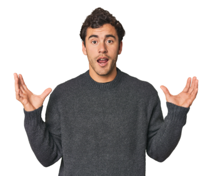 Young Hispanic man in studio screaming to the sky, looking up, frustrated.