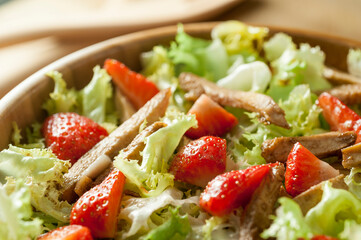 Aerial view of lettuce salad with strawberries and fried chicken
