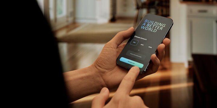 Smartphone showing donation app in hand, perfect for promoting charitable giving