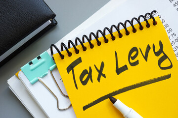 Stack of documents and notepad with inscription tax levy.
