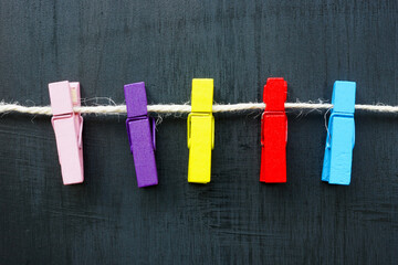 Multi-colored clothespins on a rope as a concept for diversity.