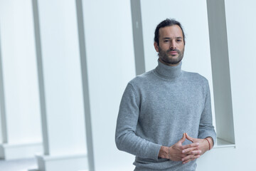 portrait d'un beau jeune homme de 35 ans souriant et pensif. C'est un employé qui pose dans les...