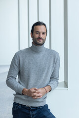 portrait d'un beau jeune homme de 35 ans souriant et pensif. C'est un employé qui pose dans les bureaux de son entreprise
