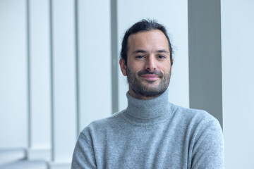 portrait d'un beau jeune homme de 35 ans souriant et pensif. C'est un employé qui pose dans les...