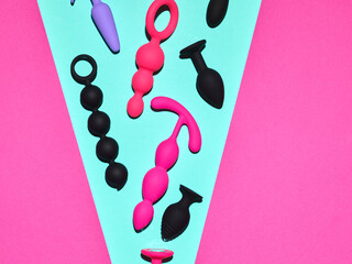 Sex toys background. Anal plugs and dildo over blue and pink backdrop