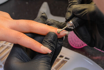 Close-up manicure process, female hands painting nails