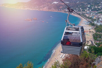 Beautiful top view of blue sea ocean water and beach shore with lots of tourists down, funicular cabin with people.Tourism destination,vacation,holiday