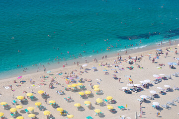Beautiful top view of blue sea ocean water and beach shore with lots many of people tourists under...